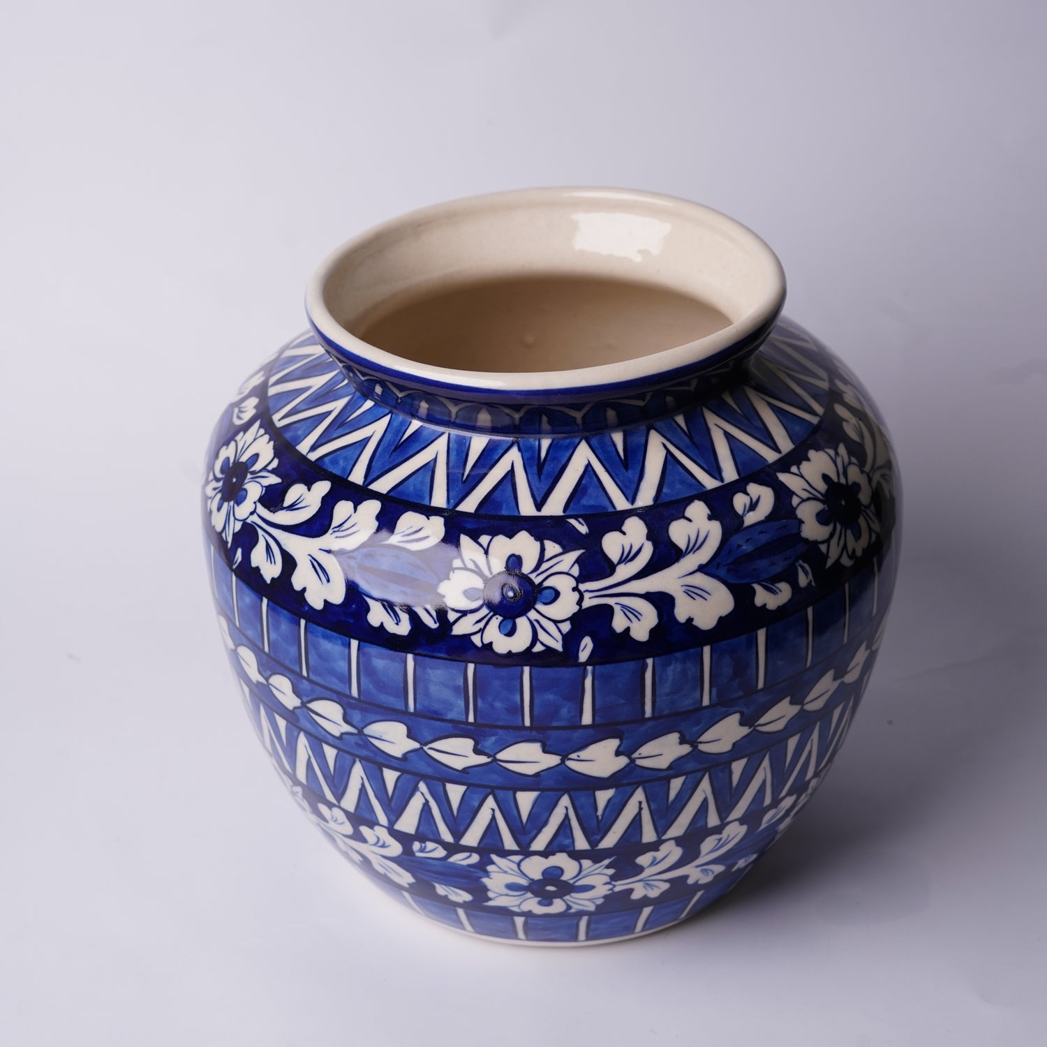Ceramic Multani Blue pottery vase with blue and white patterns on a light gray background