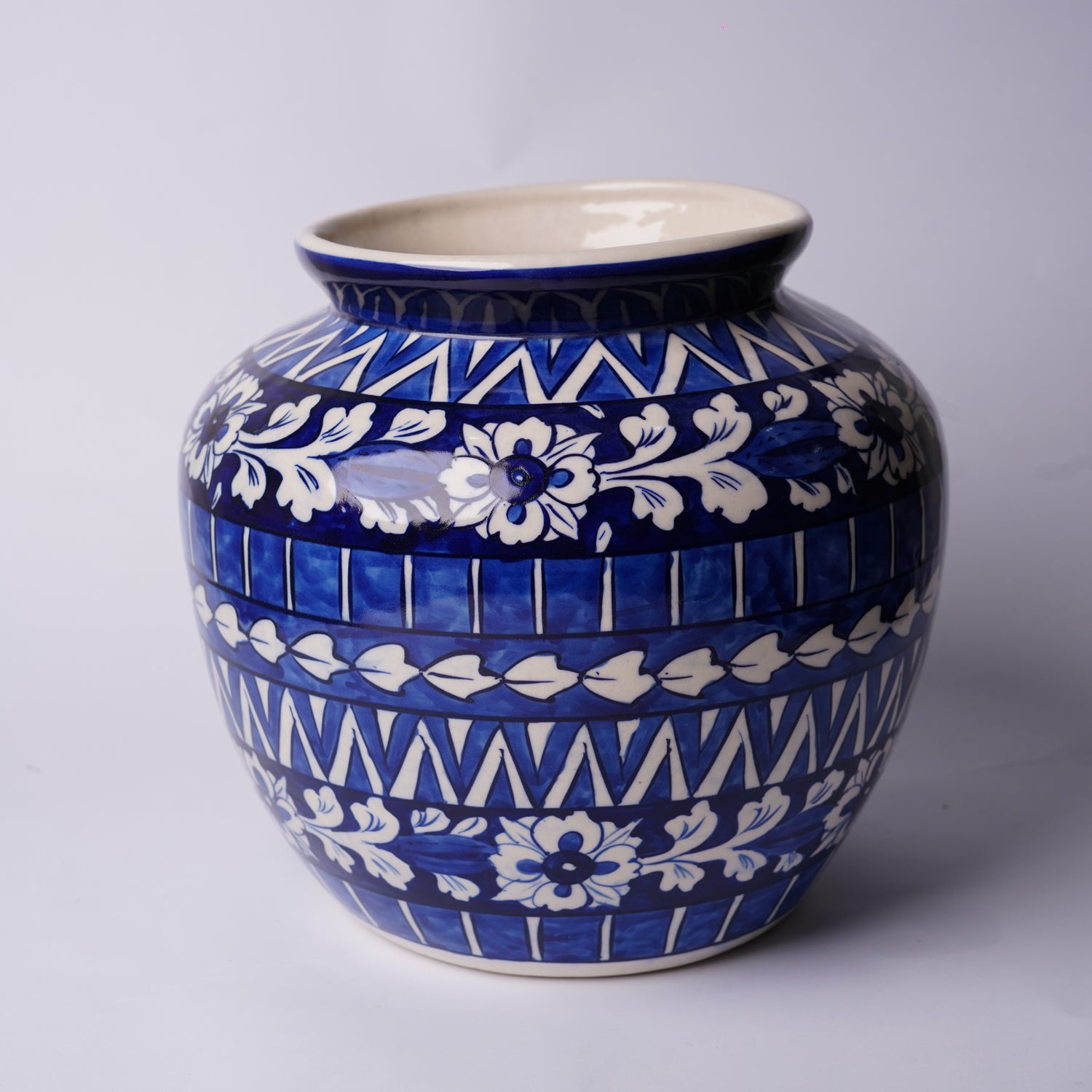 Ceramic Multani Blue pottery vase with blue and white floral patterns on a light gray background