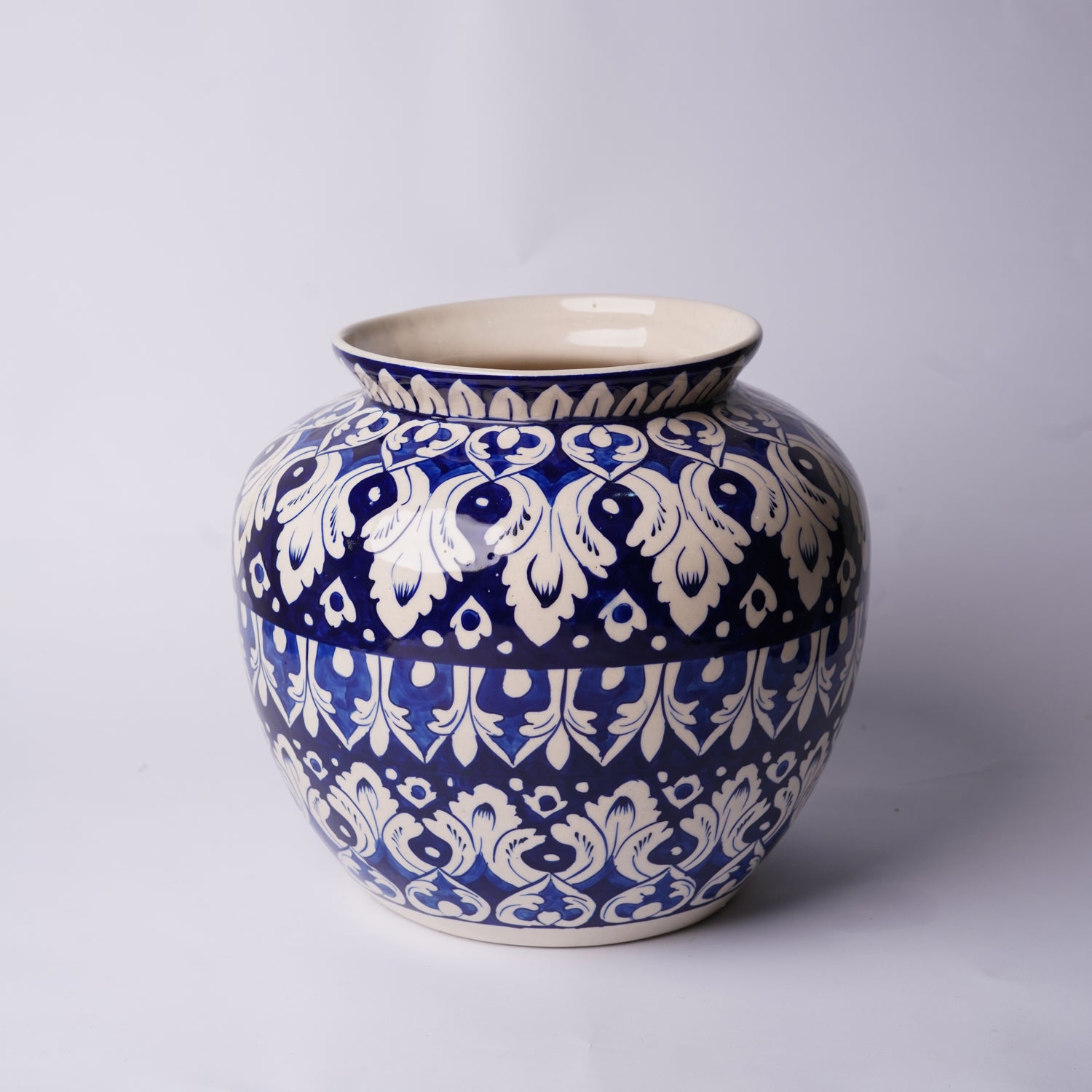 Ceramic Multani blue pottery jar with blue and white floral pattern on a light gray background