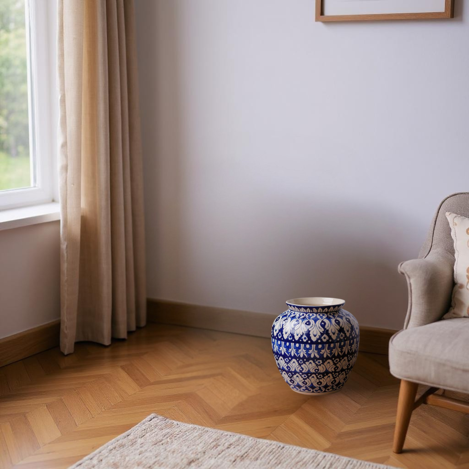 Living room with a blue and white patterned Multani blue pottery vase on a wooden floor next to a beige armchair.
