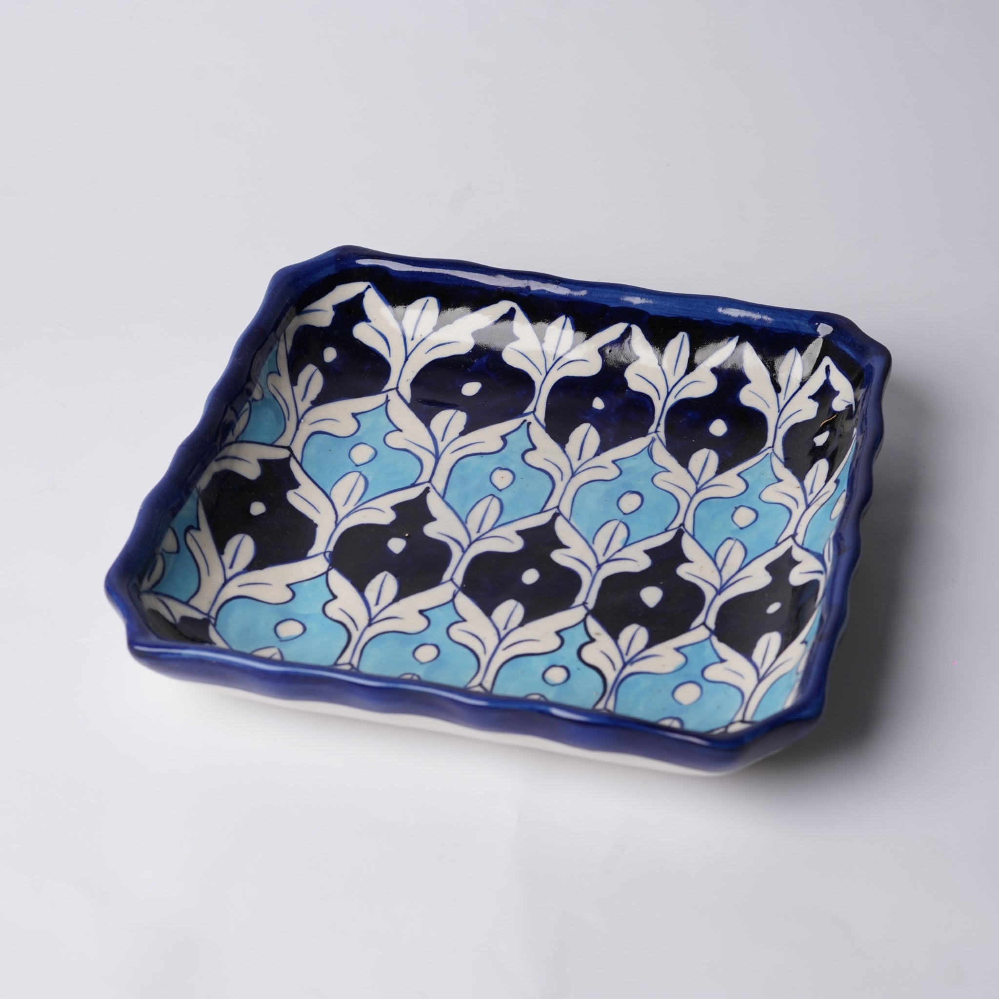 Decorative ceramic tray with blue and white floral pattern on a light gray background