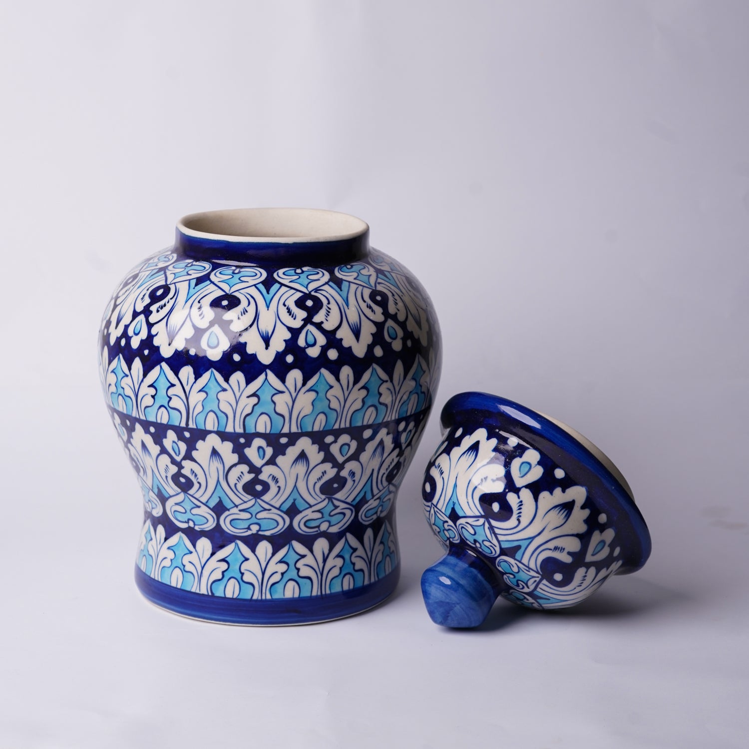 Ceramic multani blue pottery jar with blue and white decorative patterns on a light gray background