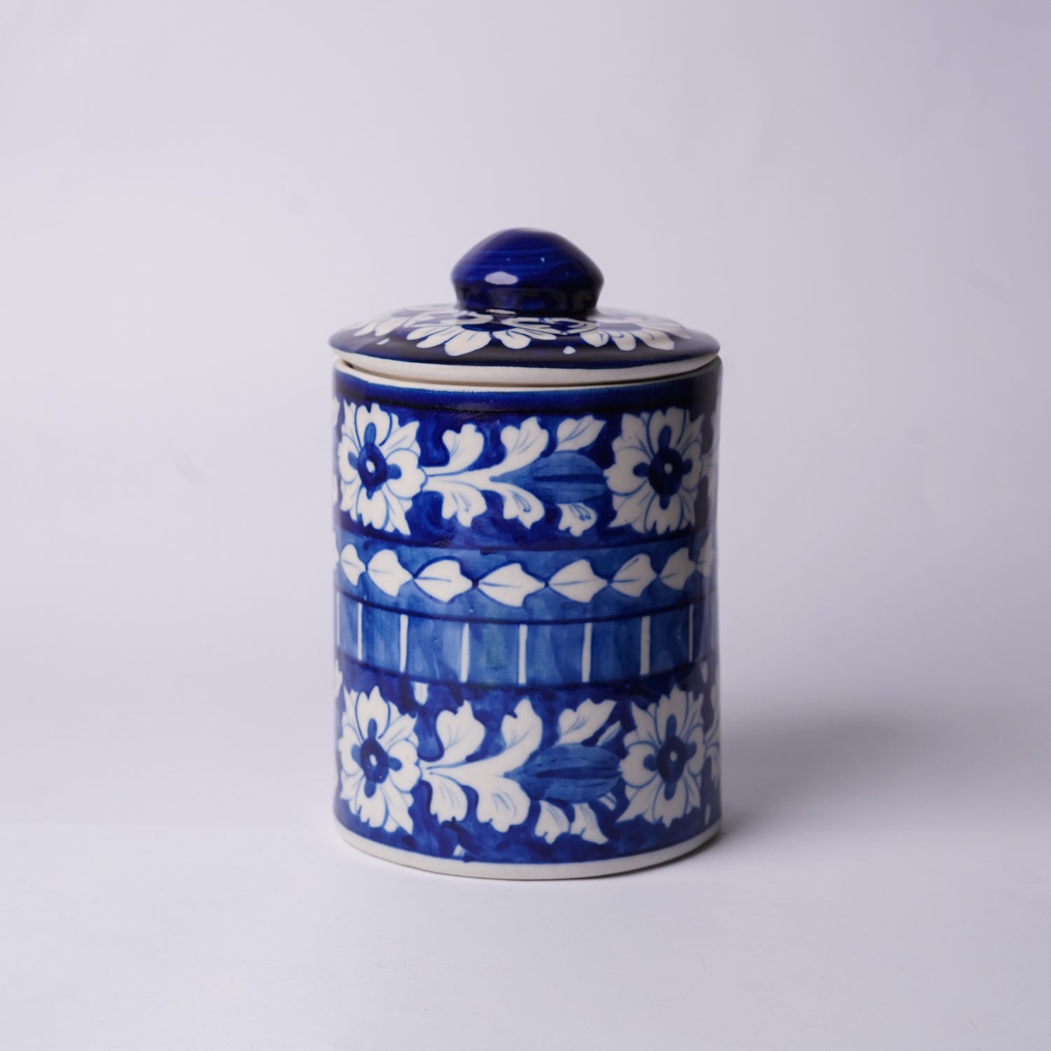 Blue and white ceramic Multani Blue Pottery jar with floral patterns on a light gray background