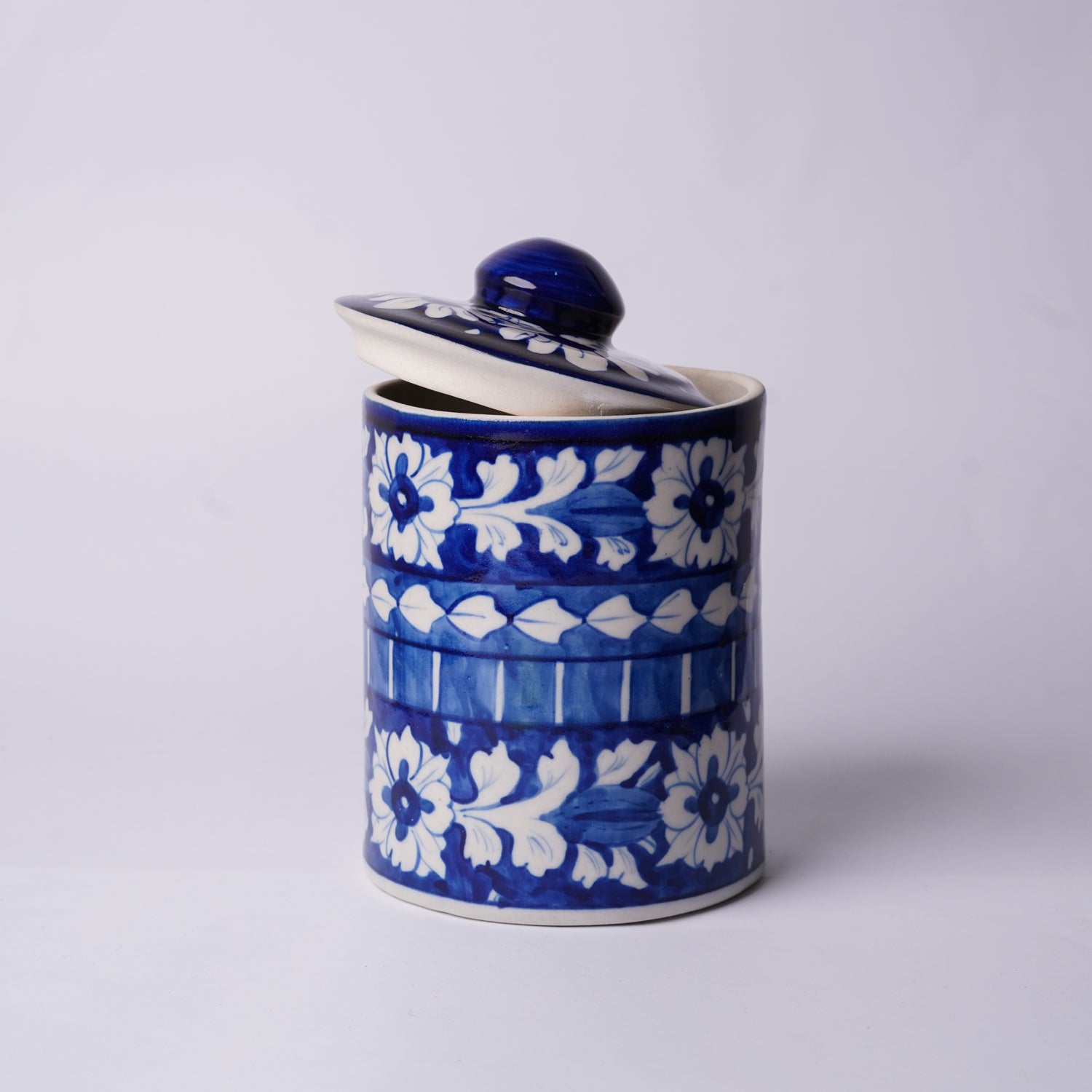 Ceramic Multani Blue Pottery container with blue and white floral pattern on a light gray background