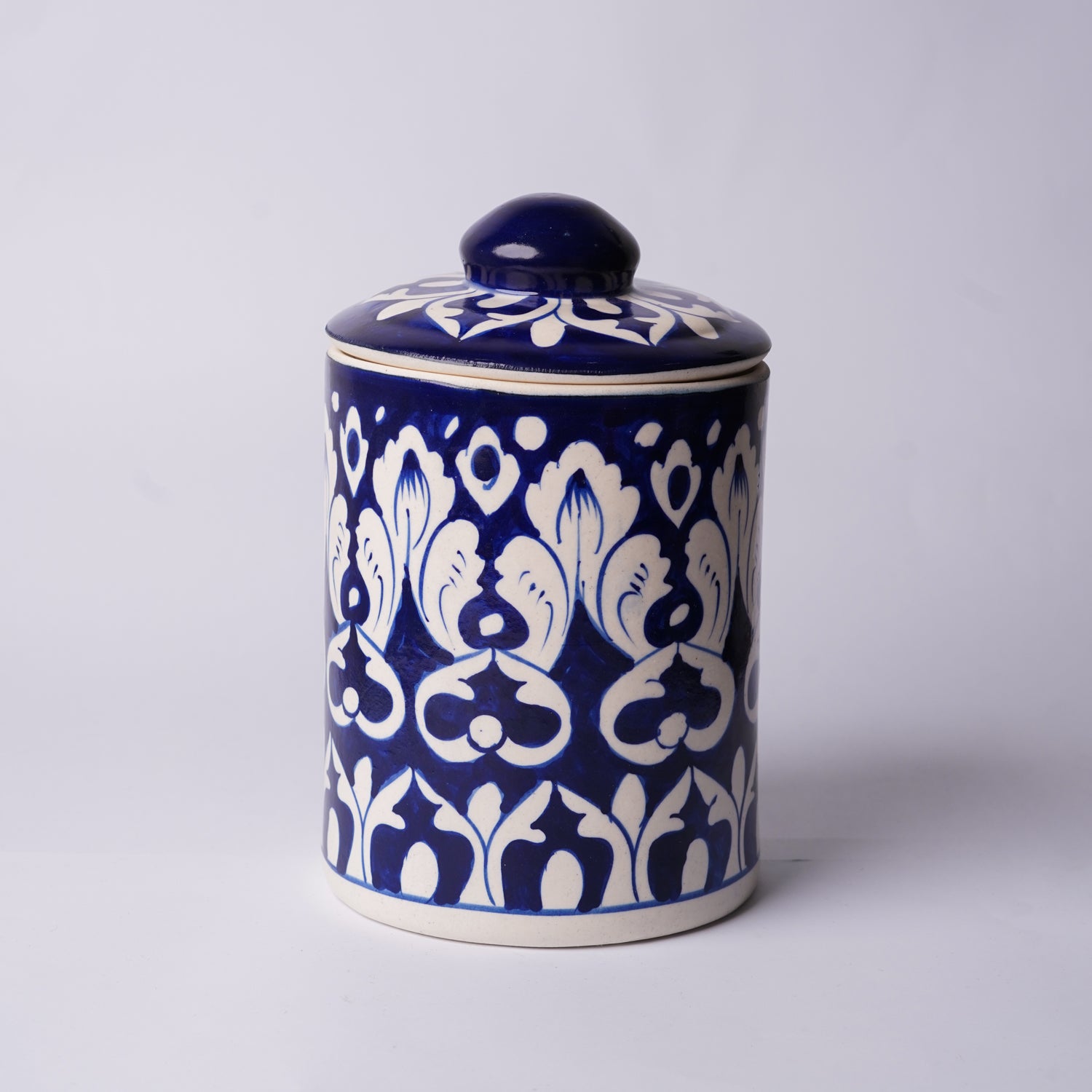 Blue ceramic Multani blue pottery jar with white floral patterns on a light gray background