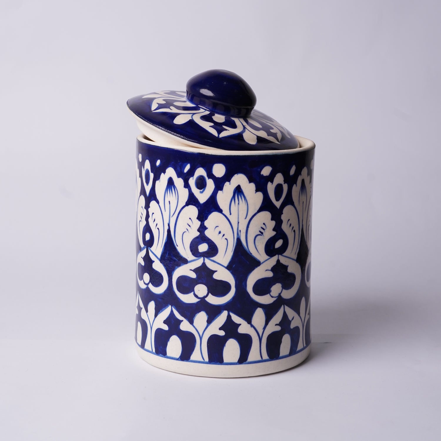 Ceramic Multani blue pottery jar with blue and white floral pattern on a light gray background
