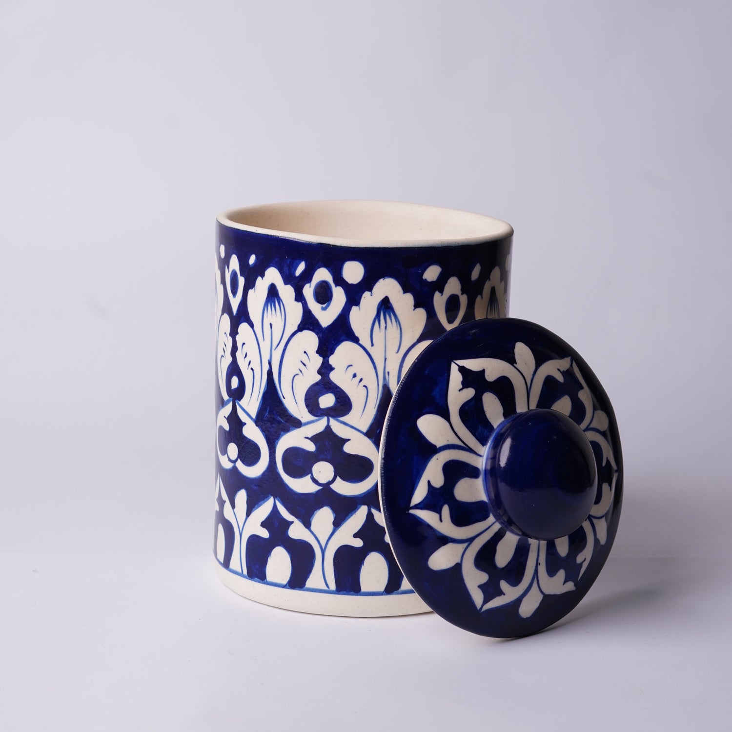Ceramic Multani blue pottery  jar with blue and white floral pattern on a light gray background
