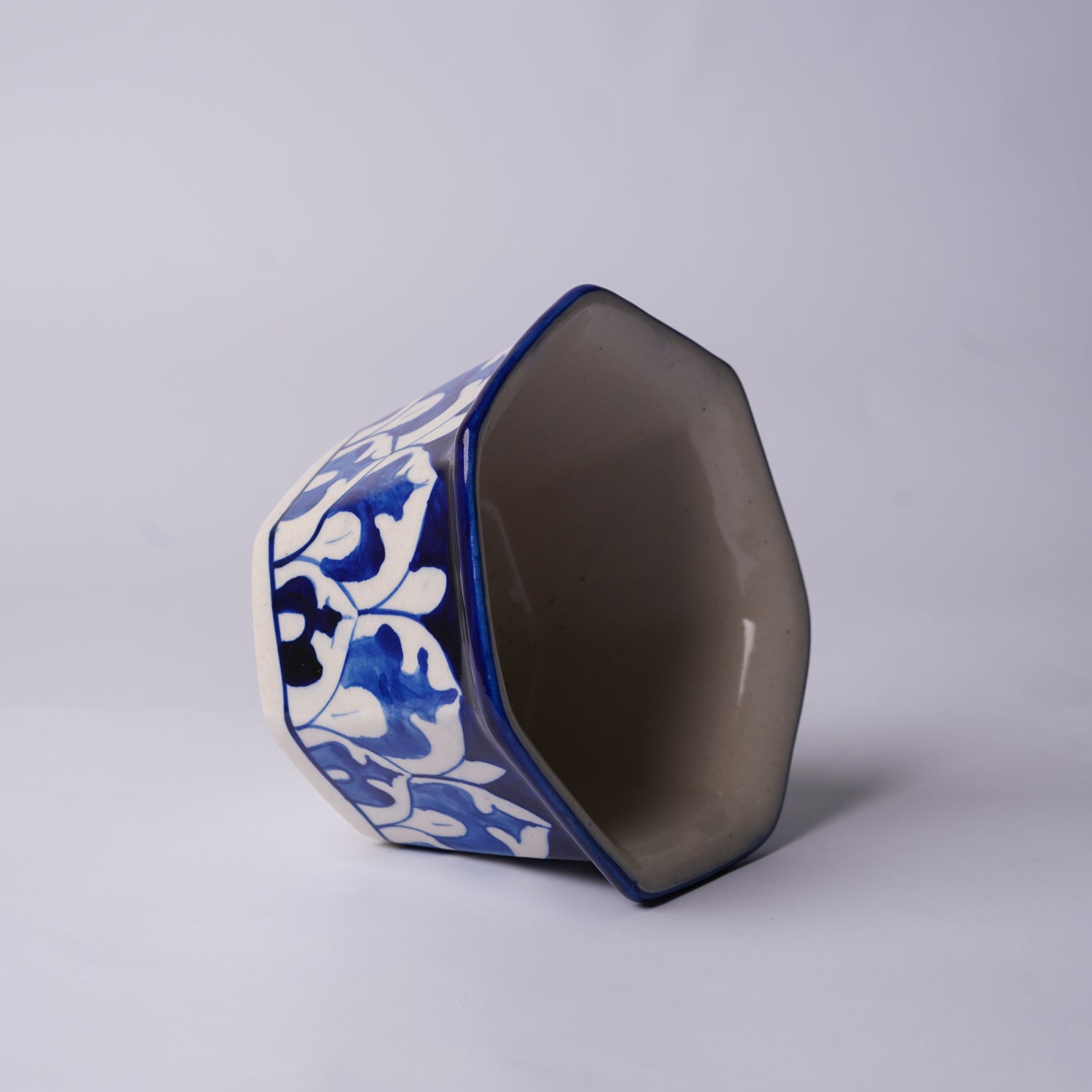 Ceramic multani blue pottery planter with blue and white floral patterns on a gray background