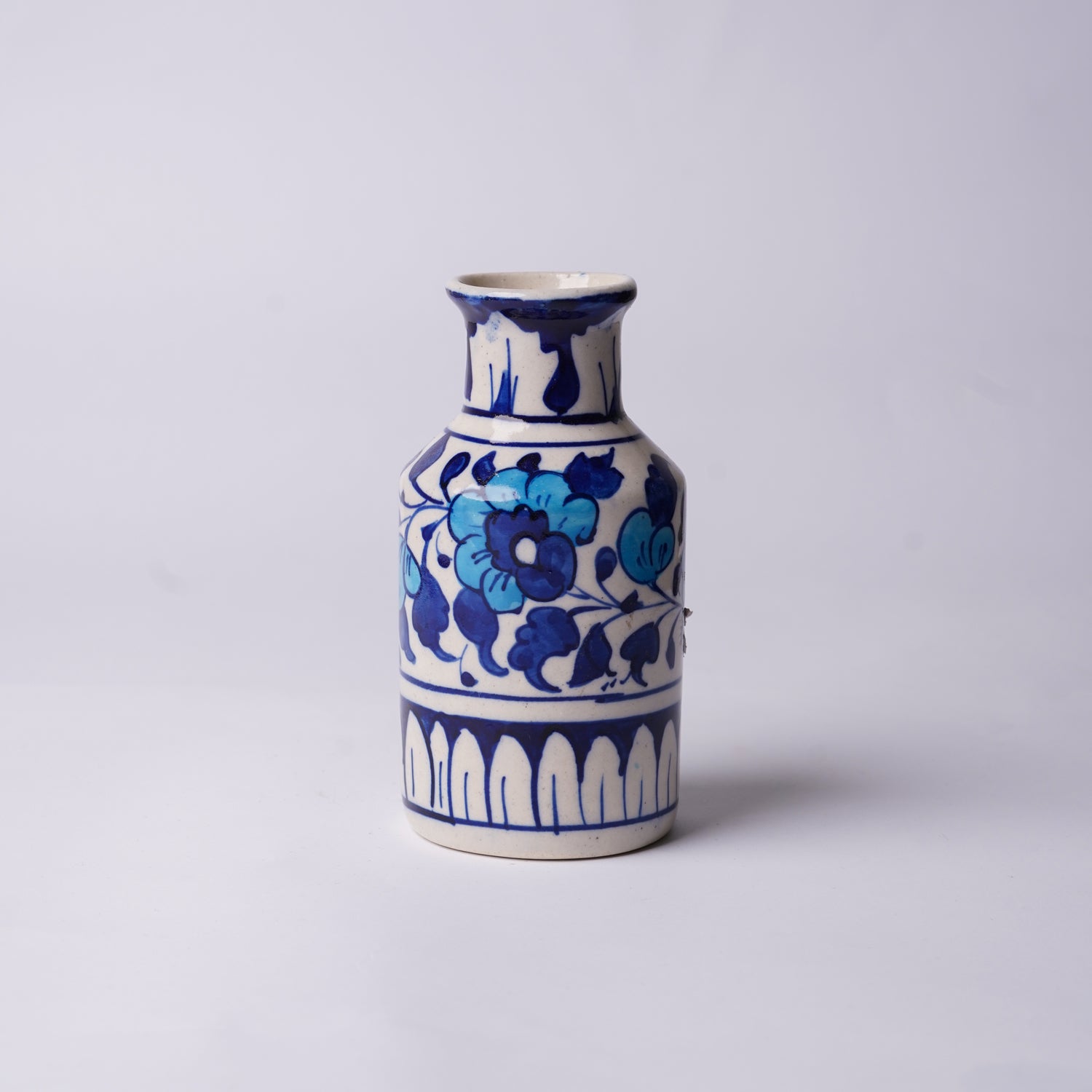 Ceramic multani blue pottery vase with blue floral patterns on a light gray background
