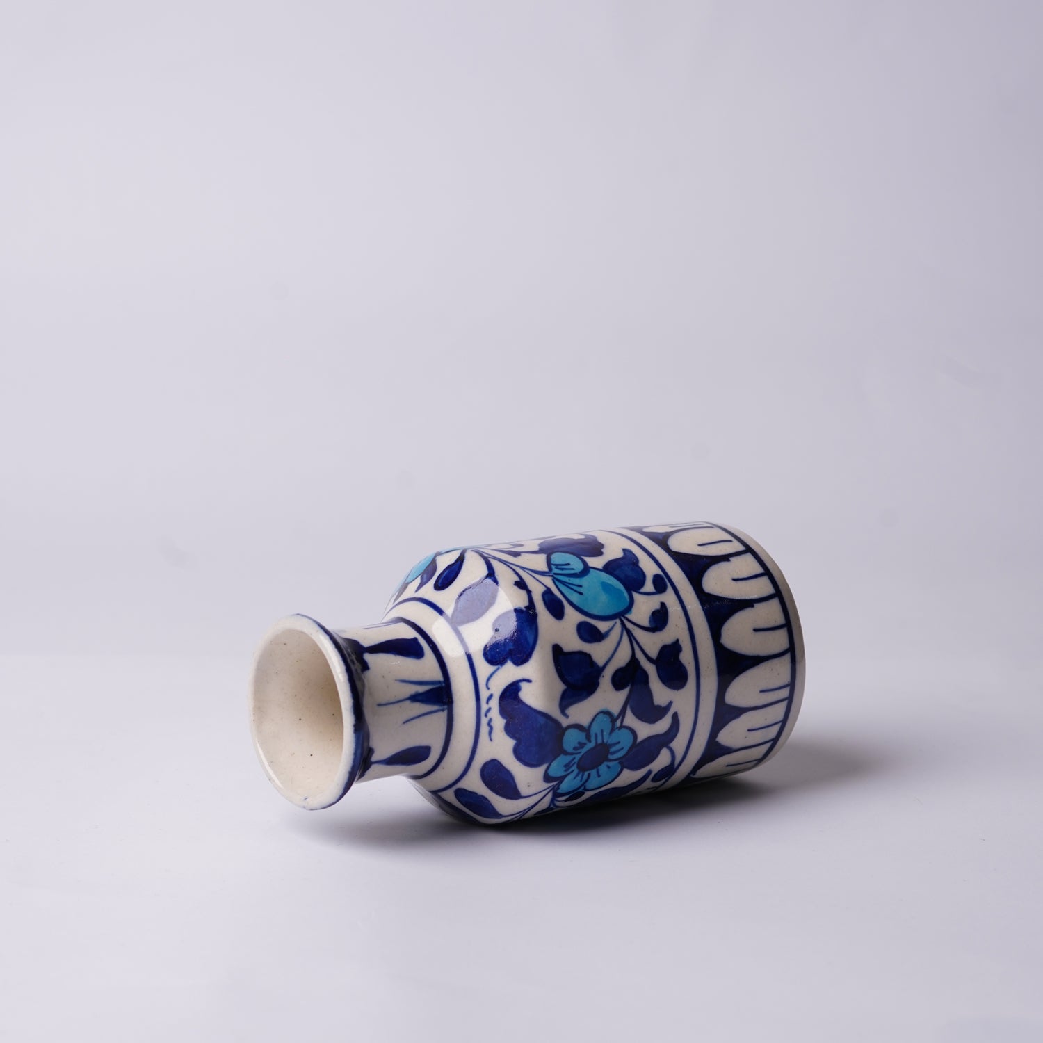 Ceramic multani blue pottery vase with blue floral patterns on a light gray background