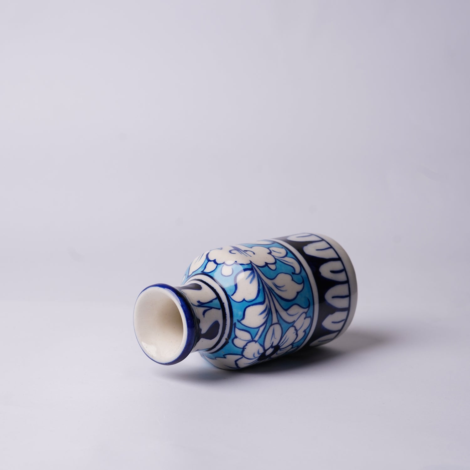 Ceramic multani blue pottery vase with blue and white floral pattern on a light gray background