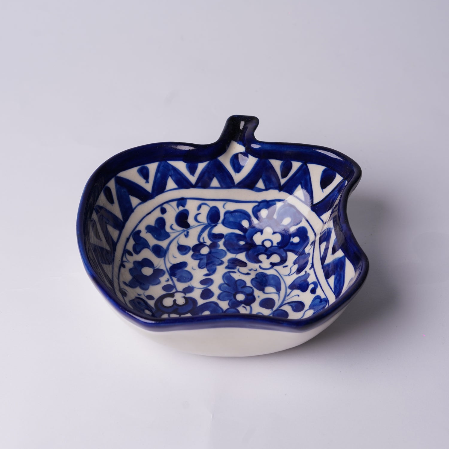 Ceramic multani blue pottery bowl with blue floral pattern on a white background