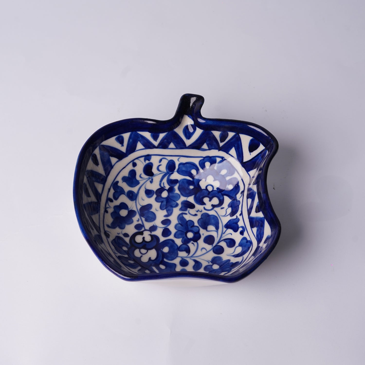 Blue and white ceramic multani blue pottery bowl with a floral pattern on a light gray background