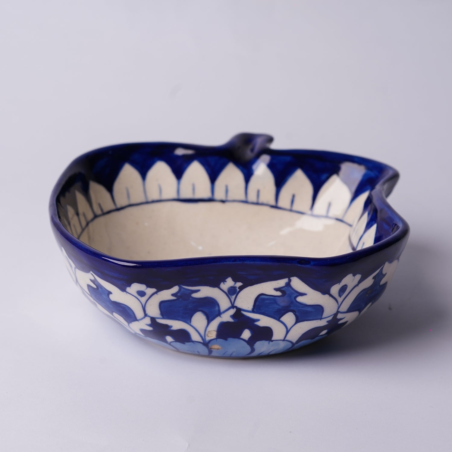 Ceramic multani blue pottery bowl with blue and white floral patterns on a light gray background