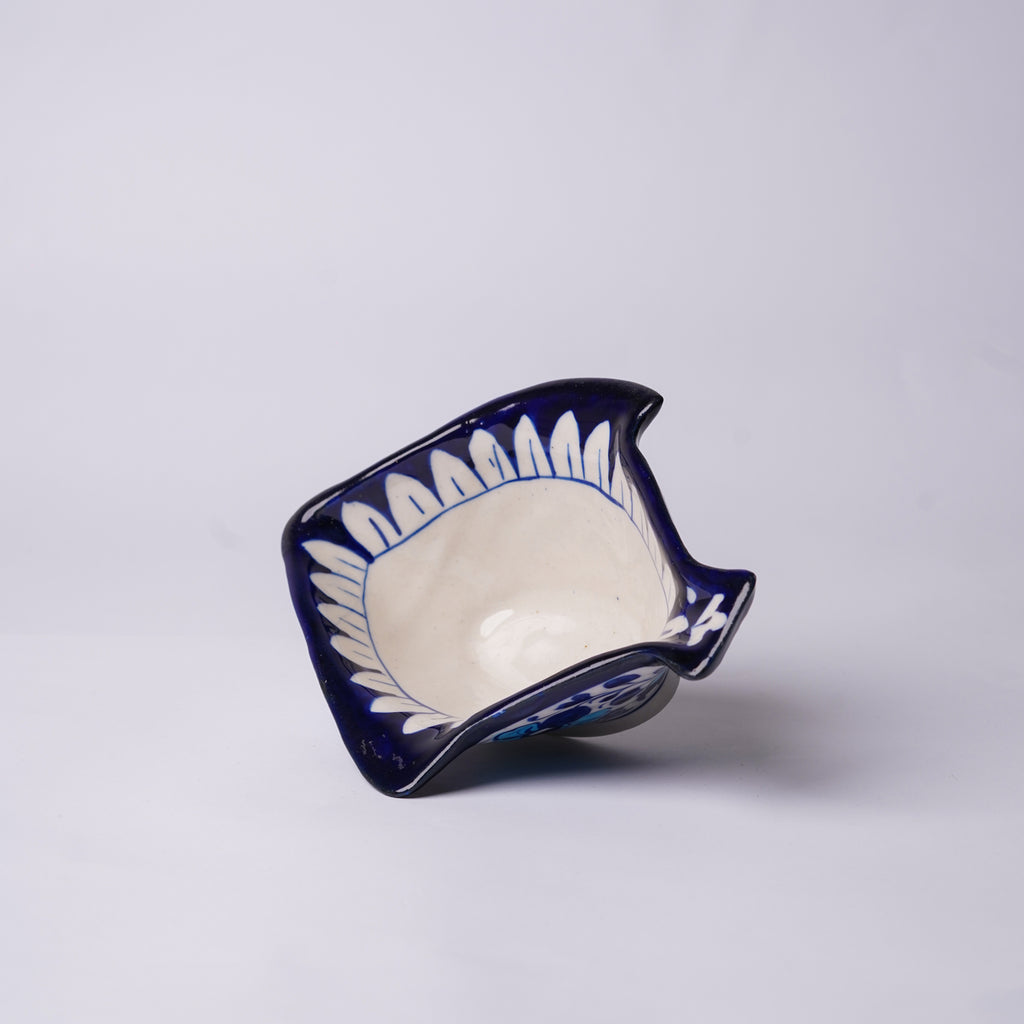 Ceramic blue pottery fish-shaped bowl with blue and white design on a light gray background
