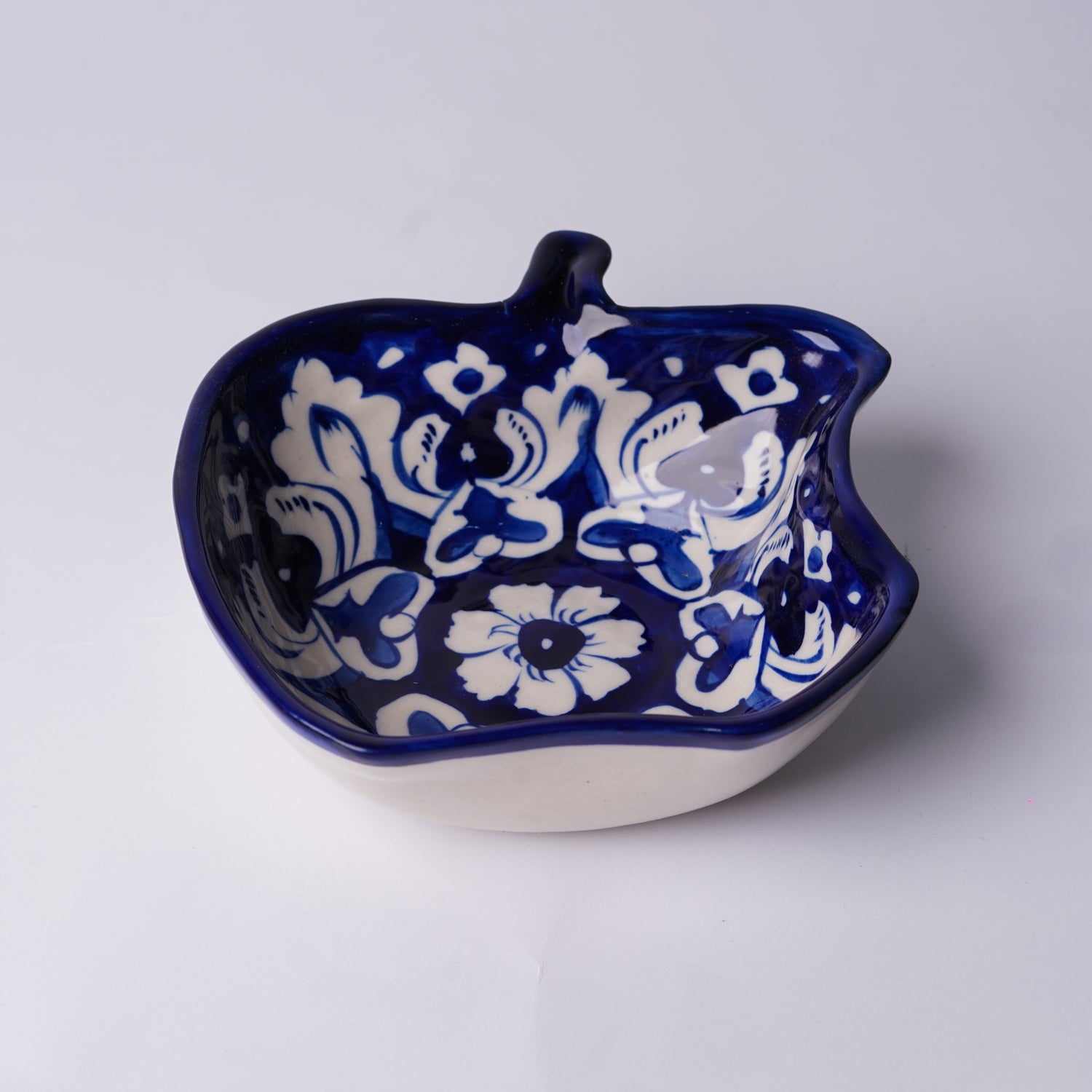 Ceramic  multani blue pottery bowl with blue and white floral pattern on a white background