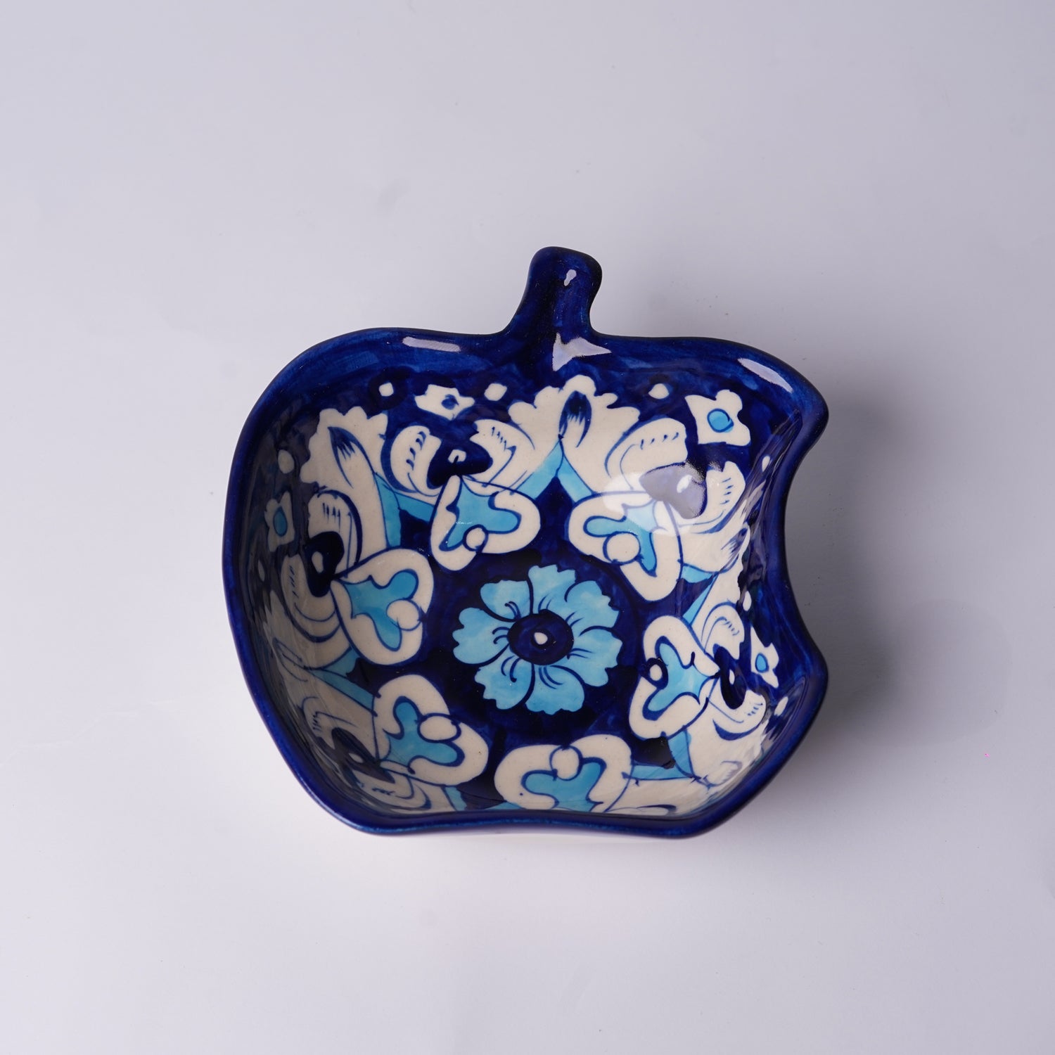 Decorative ceramic multani blue pottery bowl with blue and white floral patterns on a light gray background
