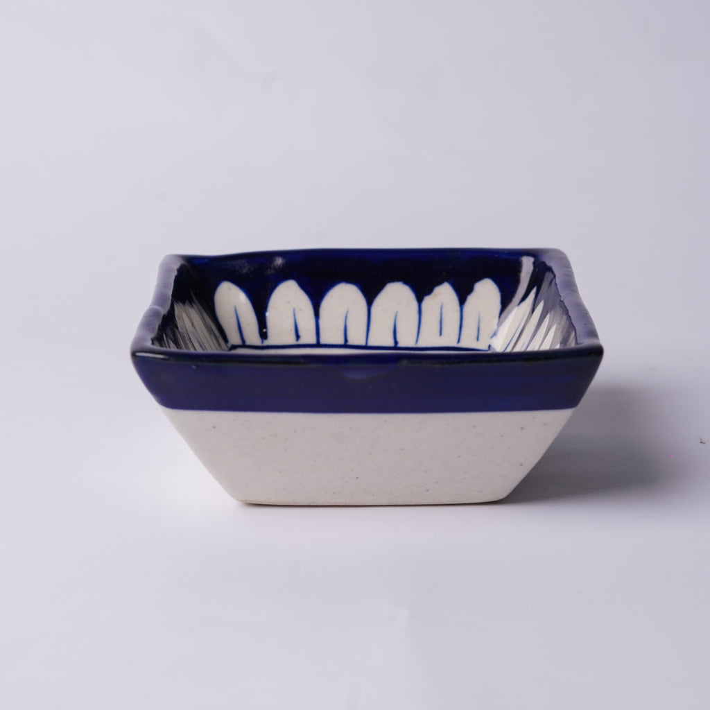Ceramic bowl with blue rim and white interior on a light gray background