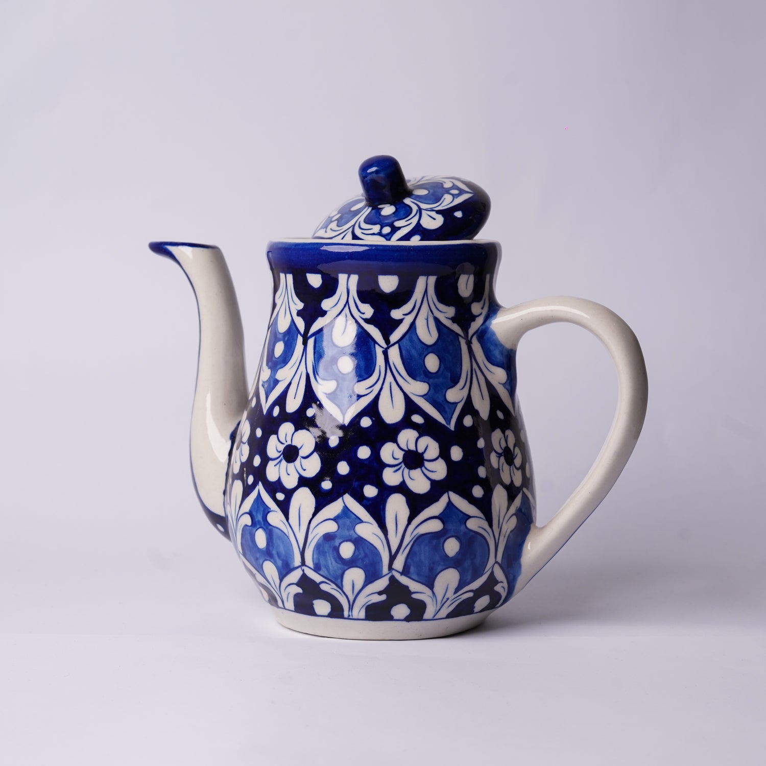Ceramic multani blue pottery teapot with blue and white floral pattern on a light gray background