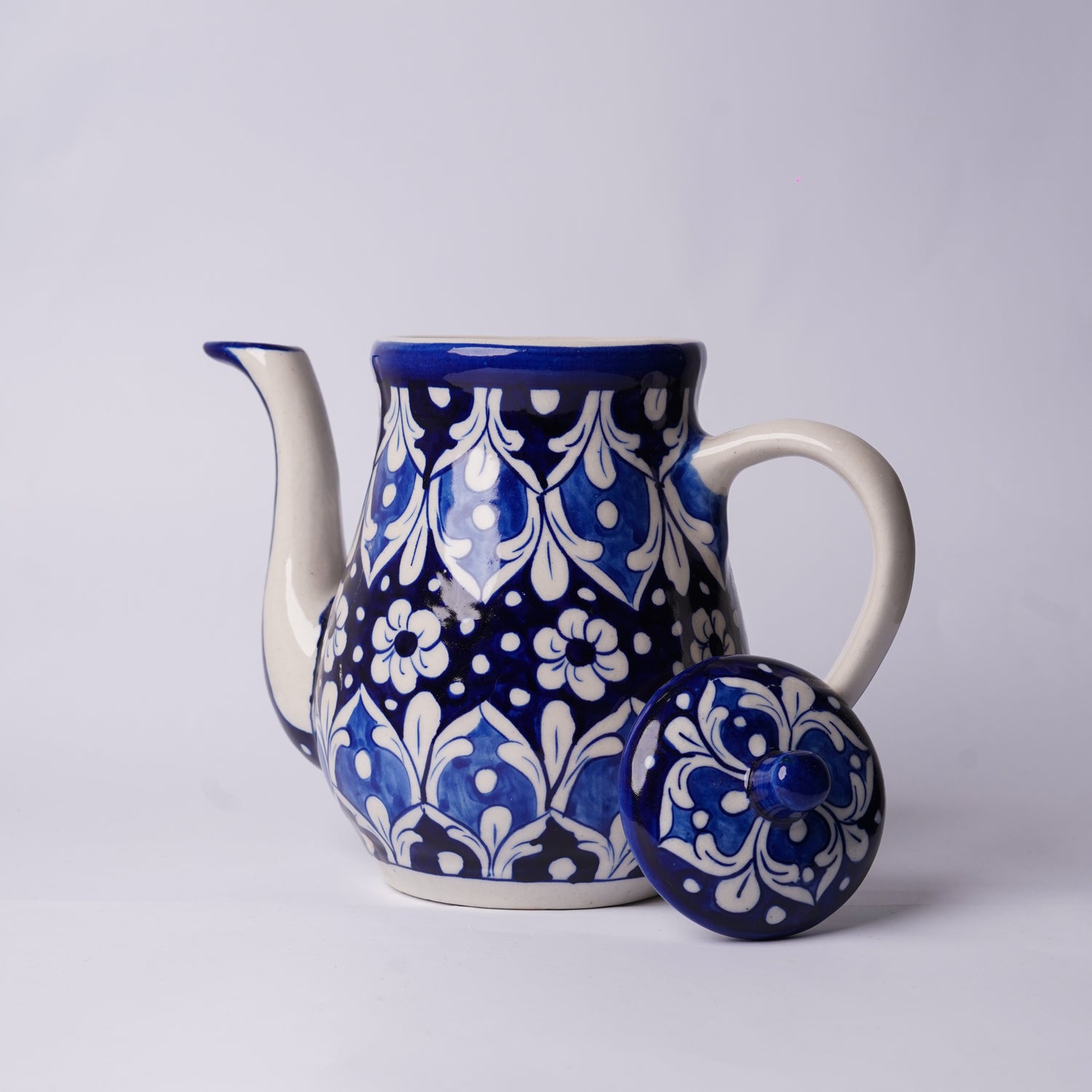 Ceramic multani blue pottery teapot with blue and white floral pattern on a light gray background