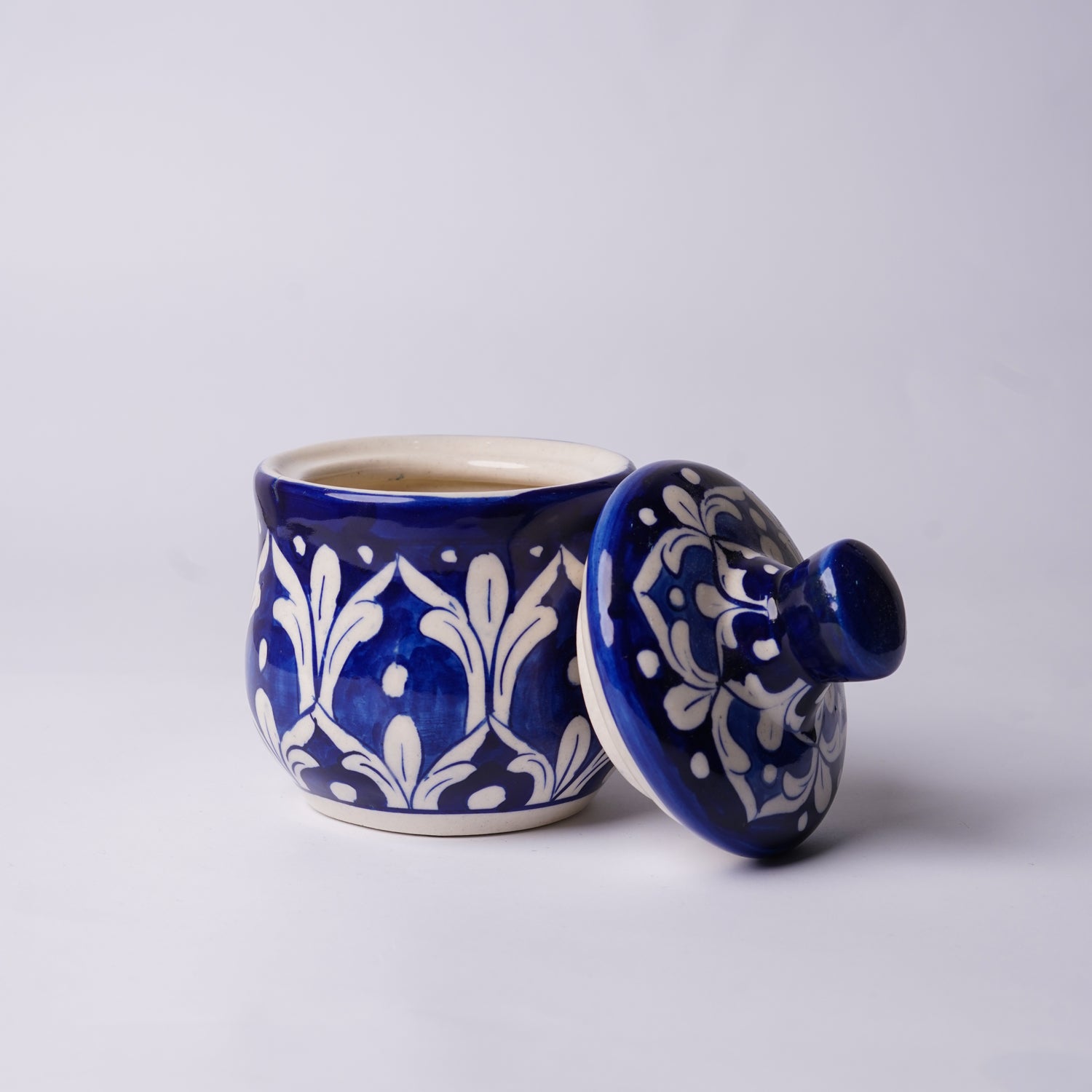 Blue and white ceramic  multani blue pottery sugar pot with lid on a light gray background