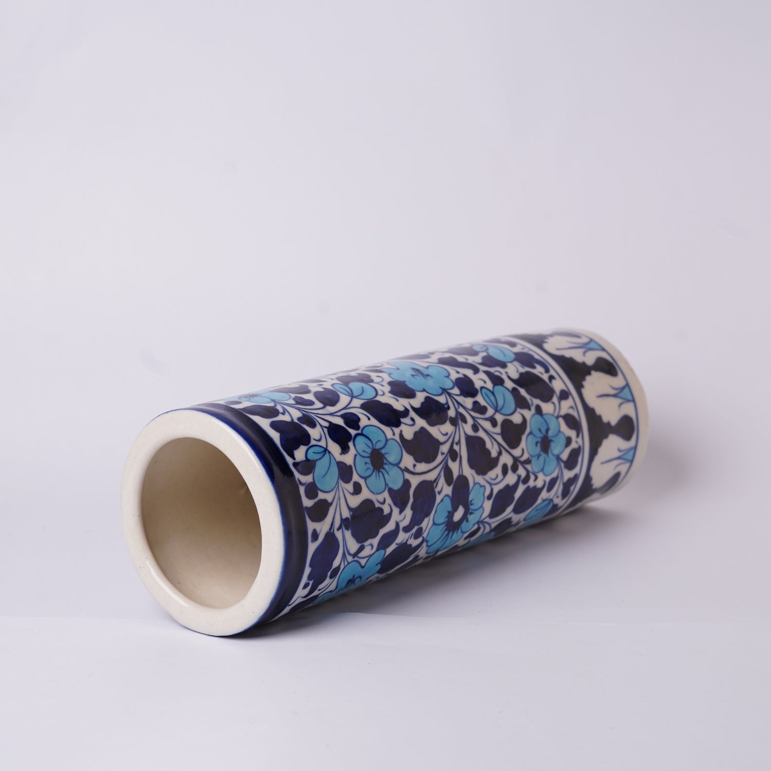 Cylindrical ceramic Multani Blue Pottery vase with a floral pattern on a white background