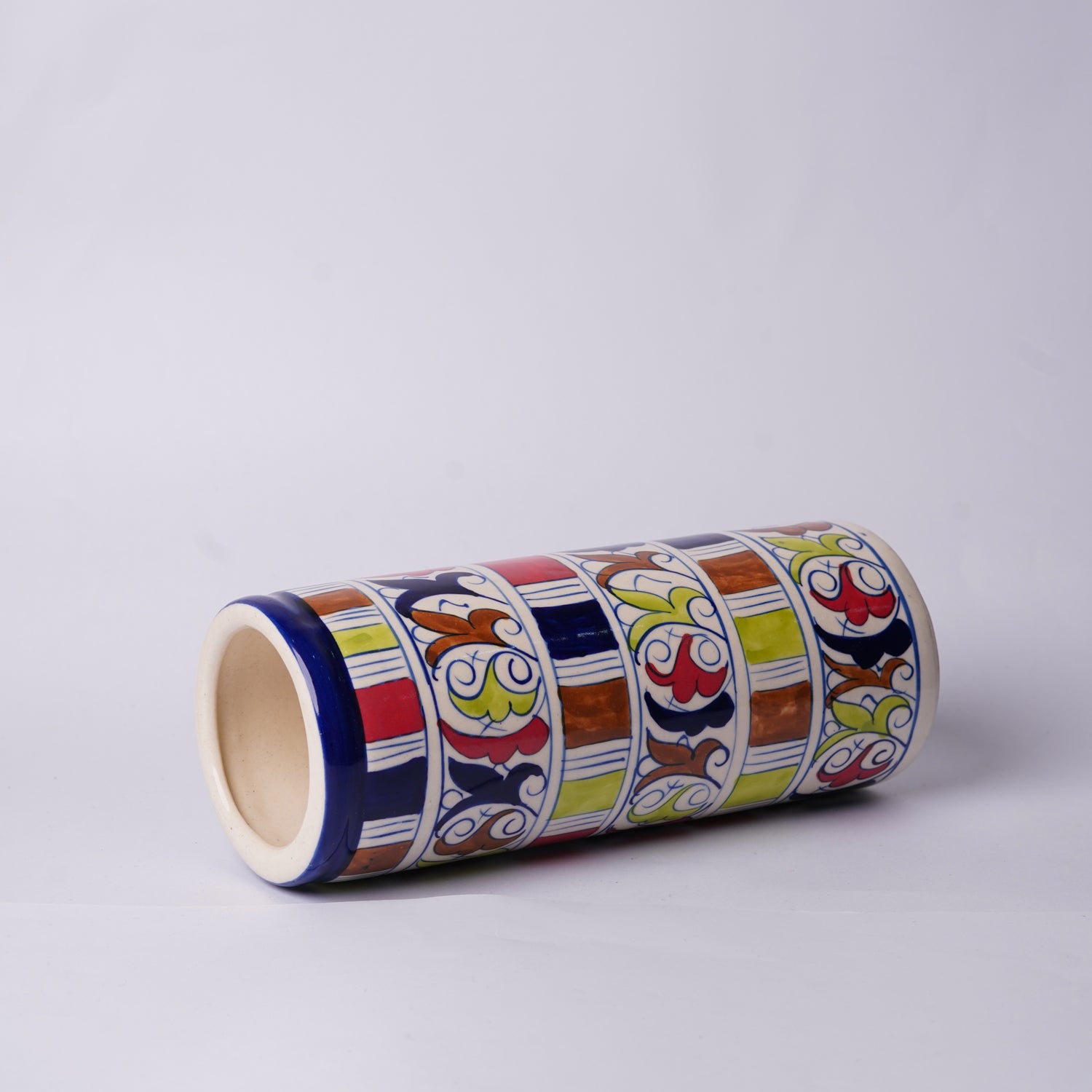 Decorative cylindrical Multani Blue Pottery vase with colorful patterns on a light gray background