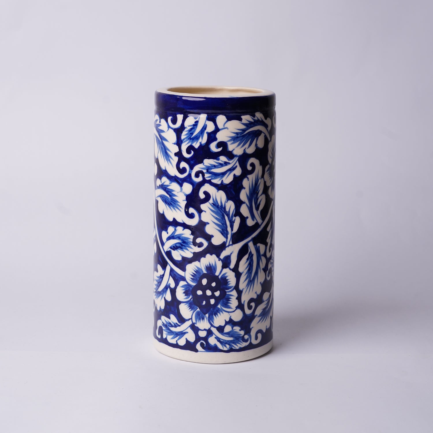 Cylindrical ceramic Multani Blue Pottery vase with blue and white floral pattern on a light gray background