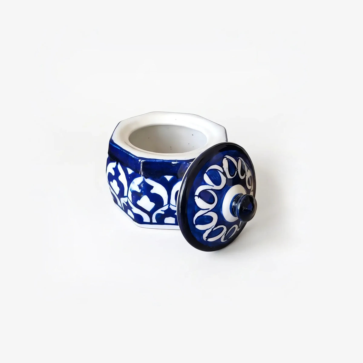 Blue pottery jewelry box open, with the looped lid propped beside it