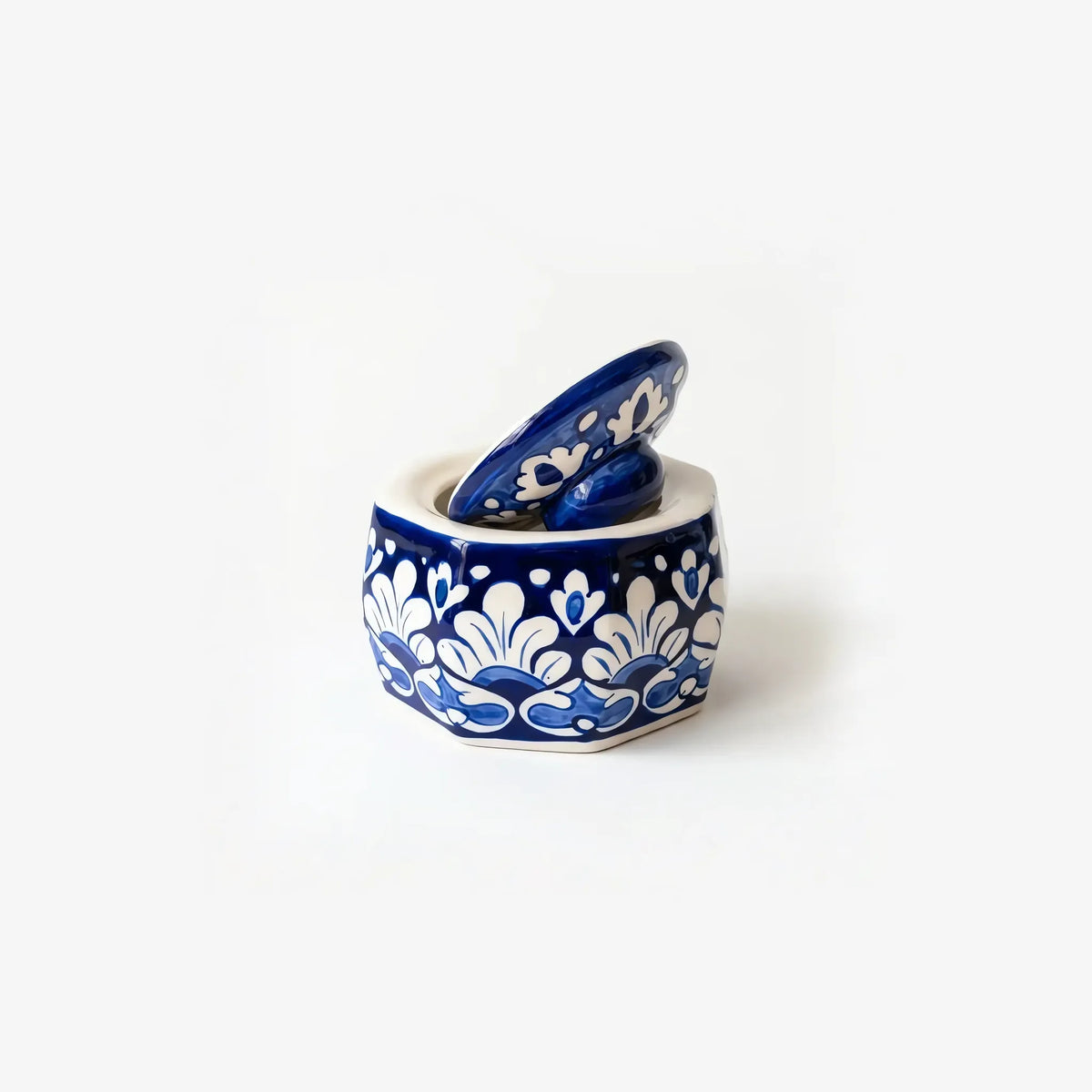 Octagonal blue pottery jewelry box with white palmette pattern, lid tilted open