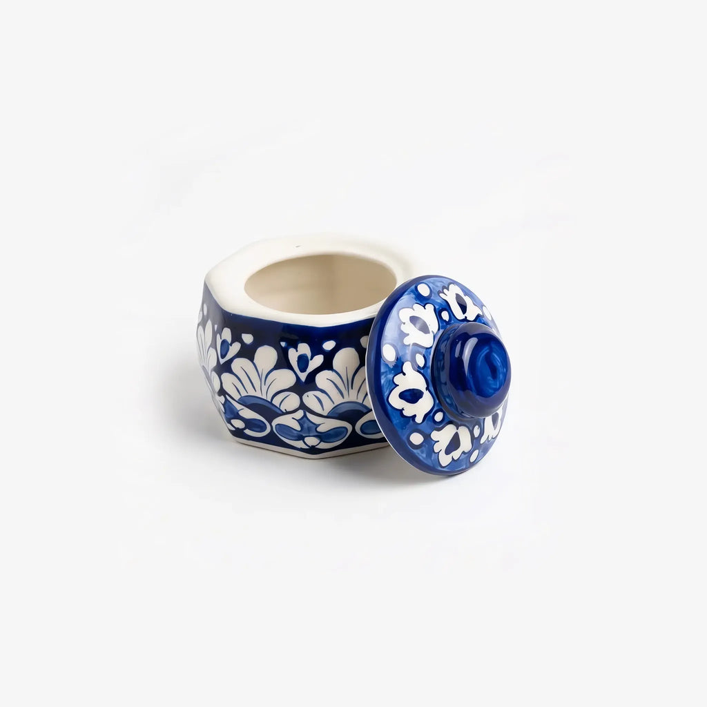 Blue pottery jewelry box open with its patterned lid propped beside it