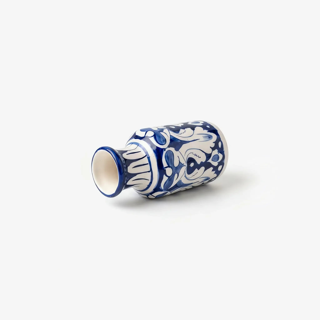 Blue pottery bottle vase lying on its side showing the glazed mouth