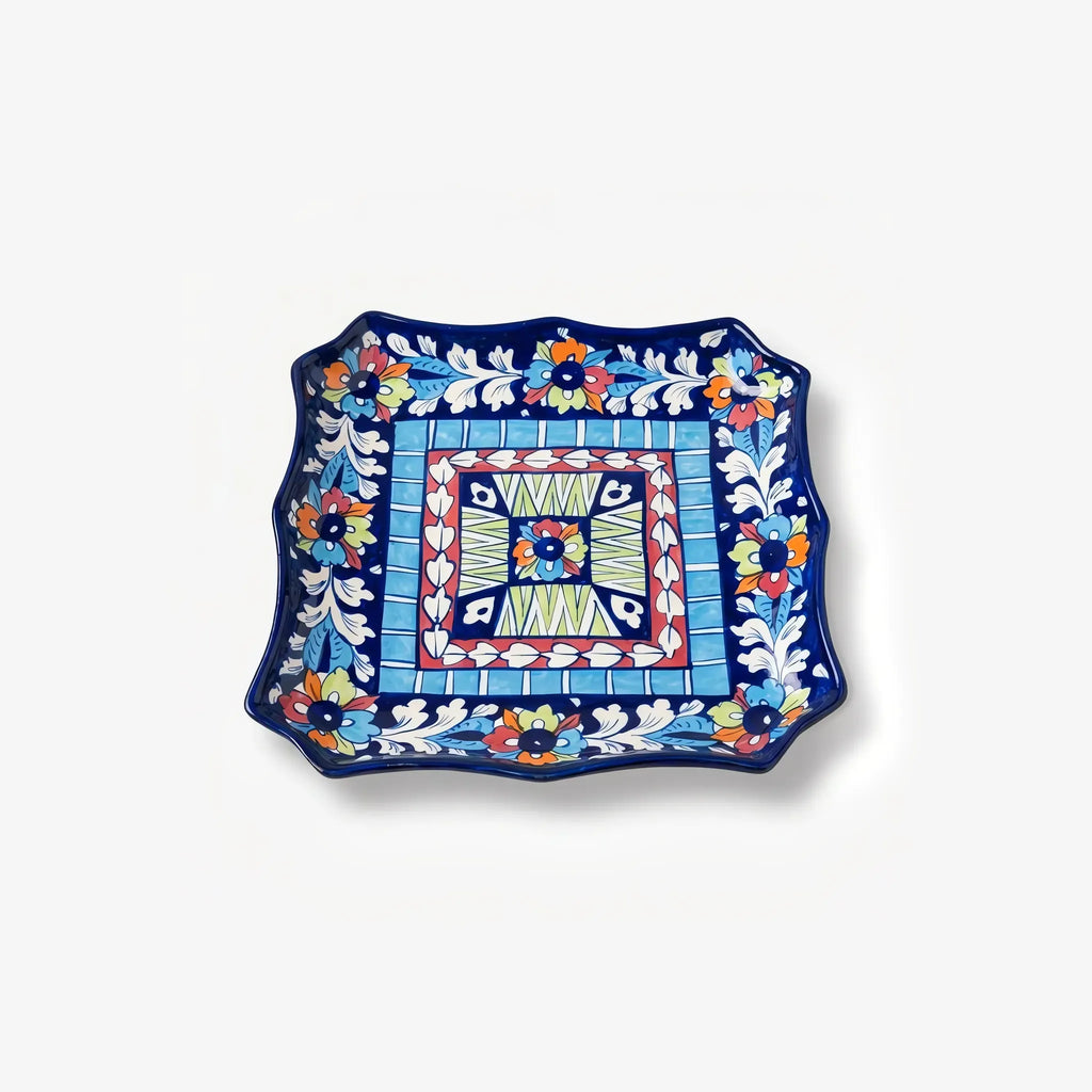 Square blue pottery serving dish with wavy edges and tile pattern
