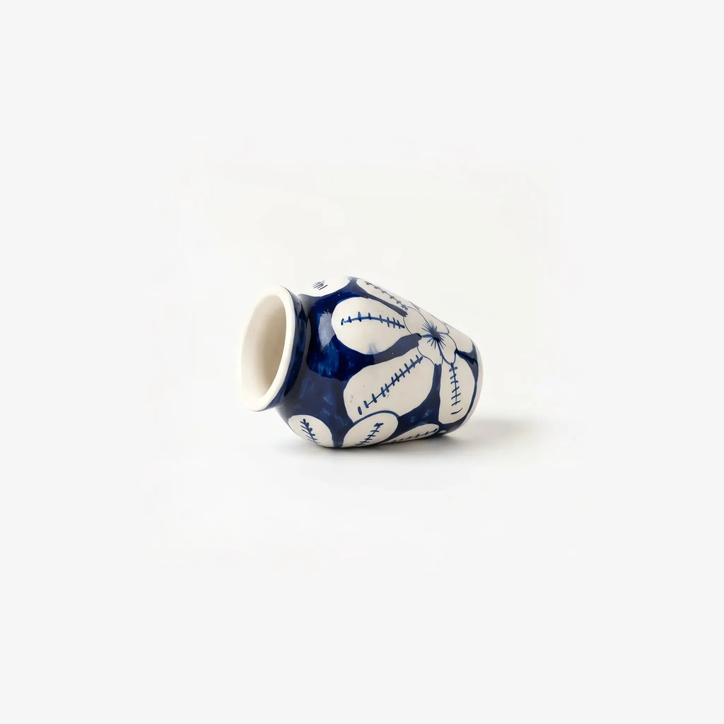 White flower mini vase lying on its side