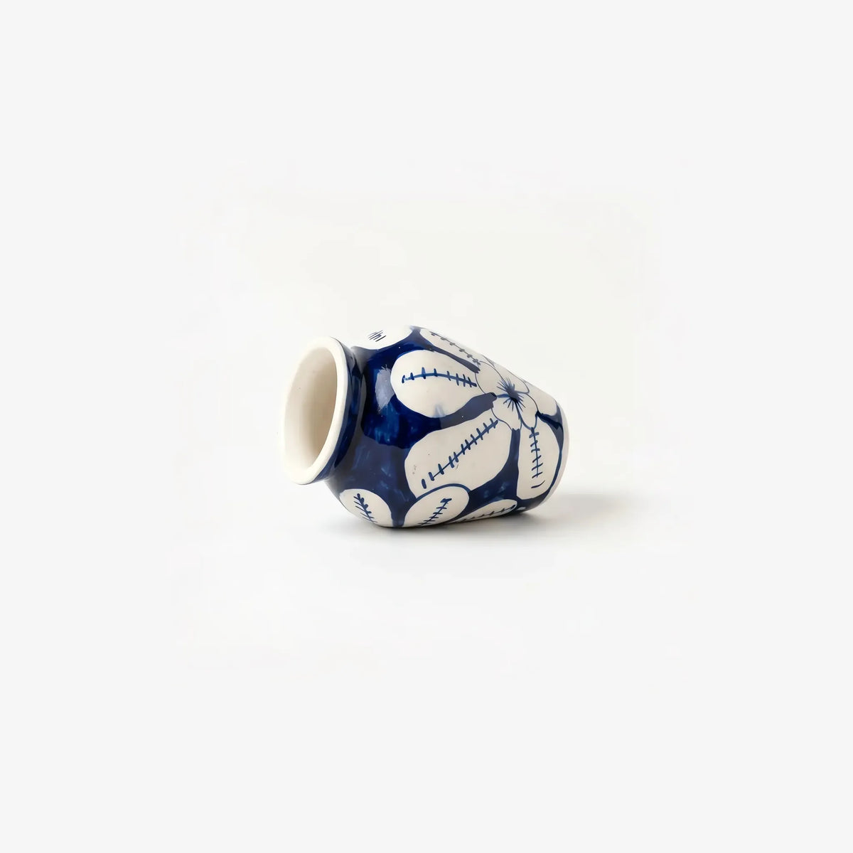 White flower mini vase lying on its side