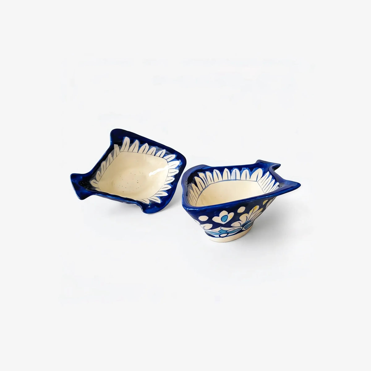 Two blue pottery fish-shaped bowls side by side