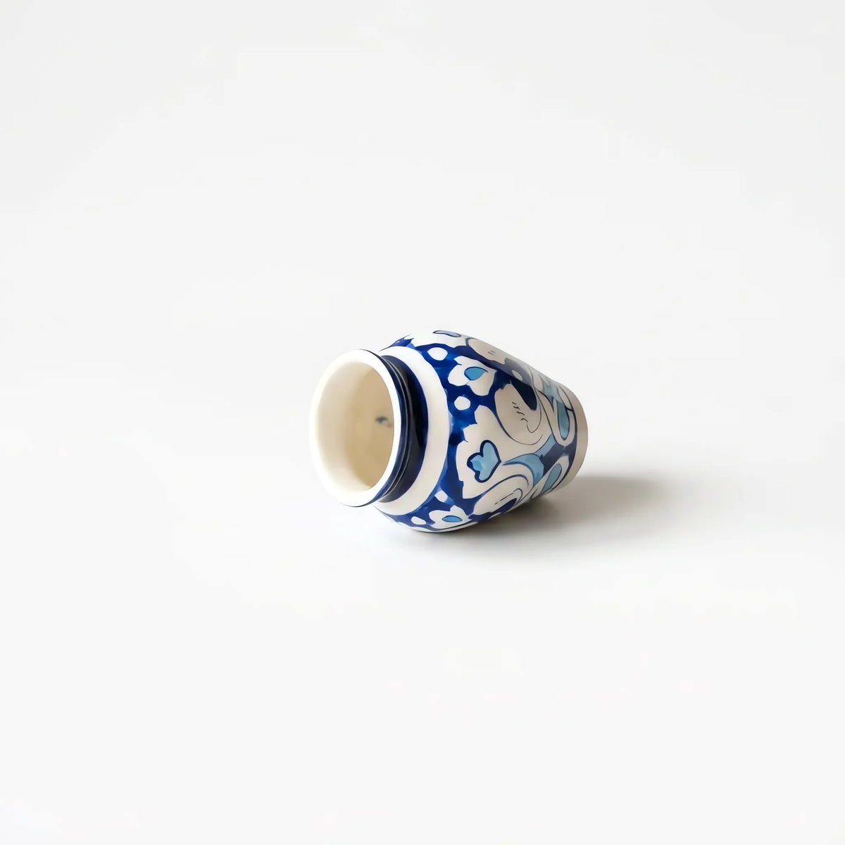 Blue pottery mini vase lying on its side