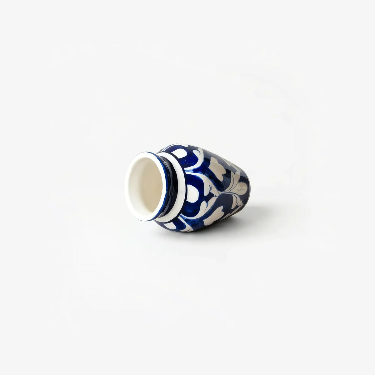 Blue pottery mini vase lying on its side