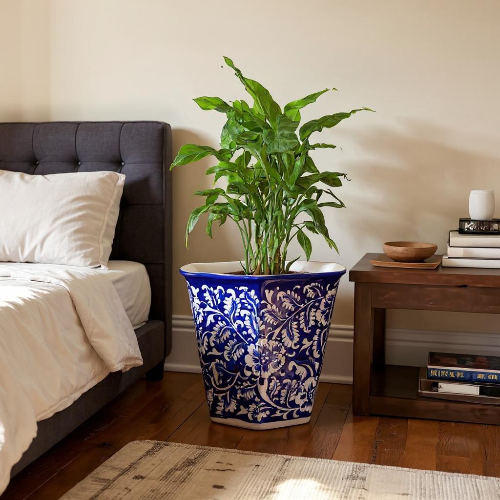 Decorative Multani Blue pottery planter in a blue and white pot next to a bed in a bedroom.